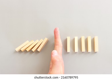A Male Hand Stopping The Domino Effect. Retro Style Image Executive And Risk Control Concept