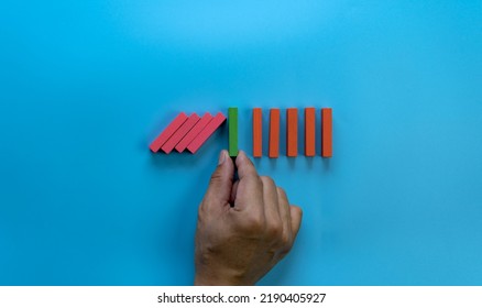 A Male Hand Stopping The Domino Effect. Retro Style Image Executive And Risk Control Concept, Blue Color Background.