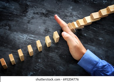 A Male Hand Stopping The Domino Effect. Executive And Risk Control Concept.