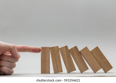 Male Hand Stopping Wooden Blocks Falling Over
