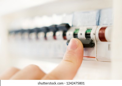 Male Hand Switching Off Fuse Board.