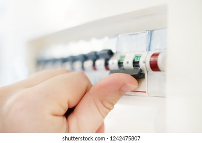 Male Hand Switching Off Fuse Board.