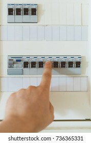 Male Hand Switching On Fuse Board.