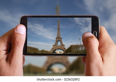 Male Hand Taking Photo Of Eiffel Tower In Paris With Cell, Mobile Phone. French Holiday.