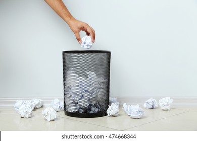 Male Hand Throwing Crumpled Paper Into Metal Trashcan