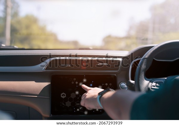 Male hand touching scrfuturistic vehicle and\
graphical user interface(GUI). intelligent car. connected car.\
Internet of Things.