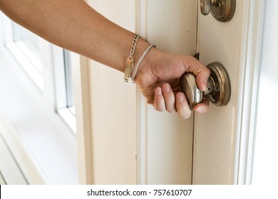 Male Hand Turning Brass Doorknob. Opening The Front Door Of The House.