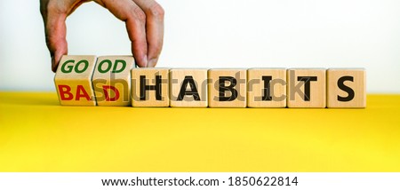 Male hand turning cubes and changes the expression 'bad habits' to 'good habits'. Beautiful yellow table, white background. Concept. Copy space.