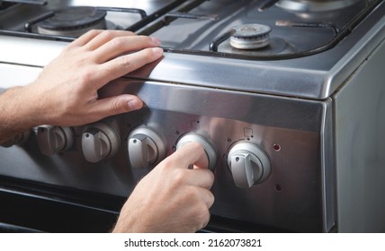 Male Hand Turning Switch Knob On Gas Stove.