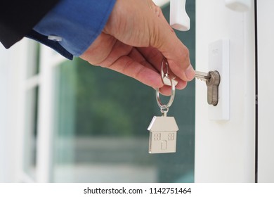 The male hand is using the key to open his own house. New home, home and homeownership concept 