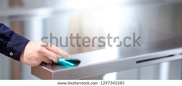Male hand using smart card to open automatic\
gate machine in office\
building