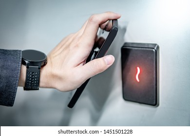 Male hand using smartphone for sensor scanning. Infrared sensor technology for automatic door access and security. - Shutterstock ID 1451501228