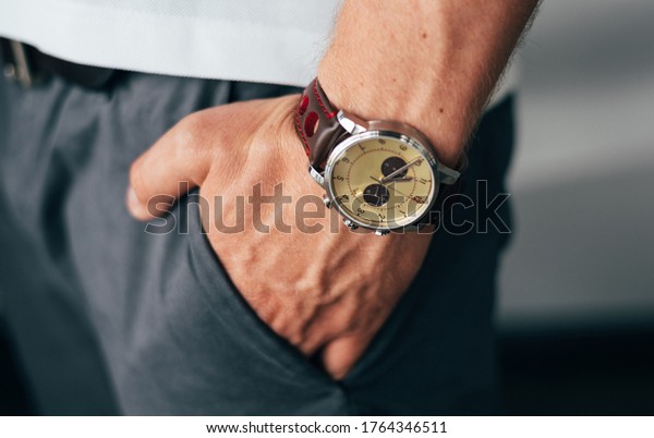 male hand with\
a watch in a pocket of\
trousers