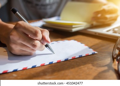 Male Hand Writing Down On Letter Paper On The Wood Desk.