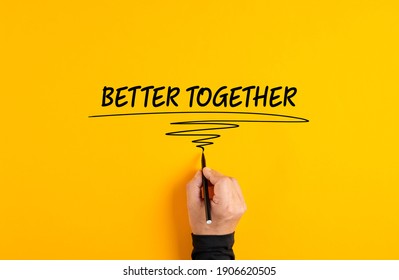 Male Hand Writing The Message Better Together On Yellow Background. Corporate Teamwork, Solidarity And Cooperation Concept.