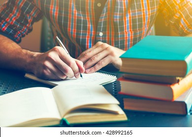 male hand writing with pen near books - Shutterstock ID 428992165
