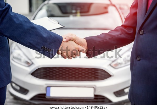 Male hands\
against car, making handshakes close\
up