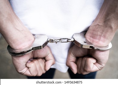Male hands arrested with handcuffs in Criminal concept. 