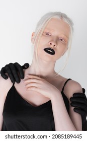 Male Hands In Black Paint Hugging Albino Model Isolated On White