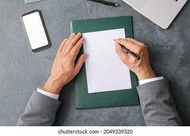 Male hands with blank paper sheet and mobile phone on dark background - Powered by Shutterstock