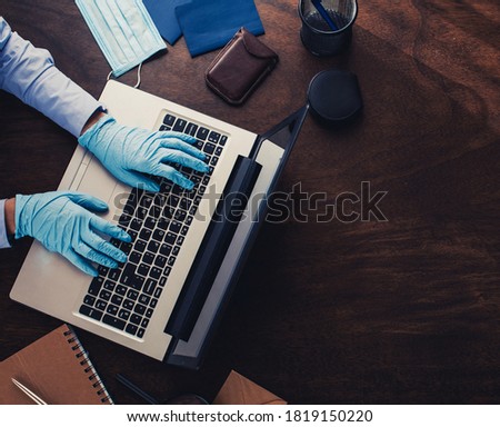 Male hands in blue protective gloves working on modern laptop. Specialist doctor in blue latex gloves.