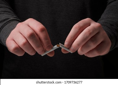 Male Hands Breaking A Cigarette. Stop Smoking Cigarettes Concept. Quit Bad Habit, Healthy Lifestyle Concept. No Smoking. Do Not Choose Wrong Lifestyle.
