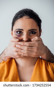 Male Hands Covering Mouth To Indian Woman With Bruise Isolated On Grey