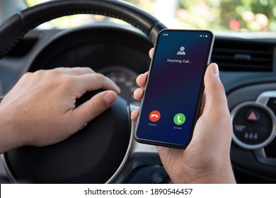 Male Hands Driving Car Holding Phone With Incoming Call On The Screen