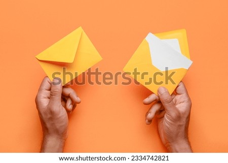 Male hands with envelopes and blank card on color background, closeup