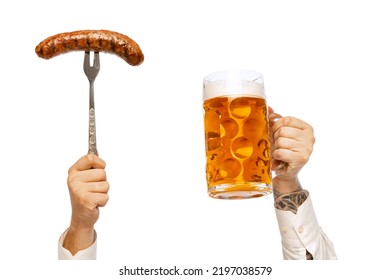 Male hands with grilled sausage on fork and mug with foamy lager beer isolated over white studio background. German and Bavarian holidays. Alcohol, Oktoberfest festival, traditions, taste concept.