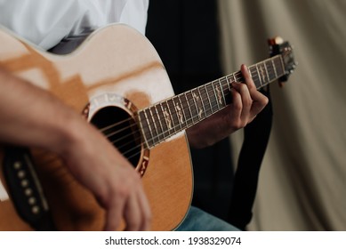 male hands and guitar close-up musician playing acoustic guitar. Music