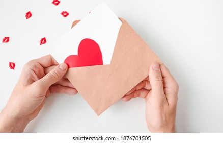 Male Hands Hold An Open Envelope With A Piece Of Paper And A Red Heart. Large Copy Space.