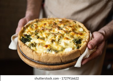 Male hands holding cheese and broccoli quiche tart. Home cooking according to French recipe. - Shutterstock ID 1727916622