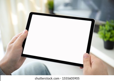 male hands holding computer tablet with isolated screen in room