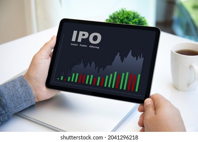 male hands holding computer tablet with IPO stocks purchase app on screen in cafe 