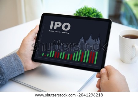 male hands holding computer tablet with IPO stocks purchase app on screen in cafe 