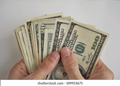 Male hands holding and counting the pile of US Dollars (American currency, USD) as a symbol of business success