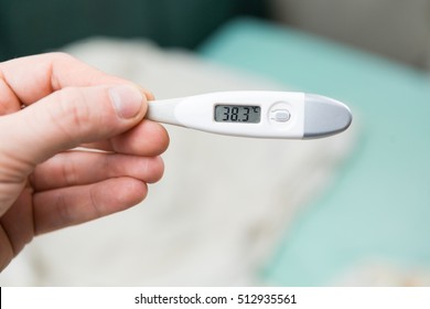 Male hands holding a digital thermometer with high temperature