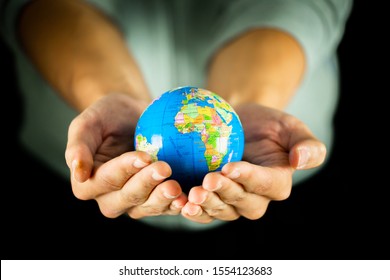 Male Hands Holding The Earth Globe On Black Background