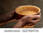 Male hands holding empty plate on dark background, lack of food, hunger and crisis concept
