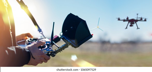 Male hands holding generic design dron remote controller doing some setings ready to run it into the sky. Cropped shot of man adjusting digital telemetry radio system. Active timespending at sunny day