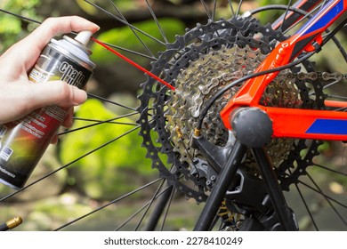 A male hands holding lubricant spray for lubricating mtb bicycle chain - Powered by Shutterstock