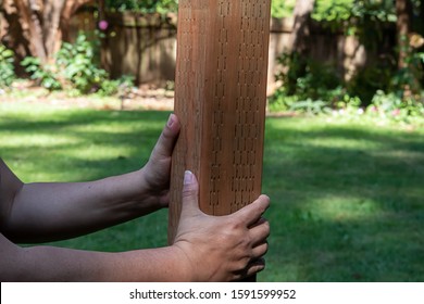 Male Hands Holding Up A Lumber 4x4 Support For A Fence