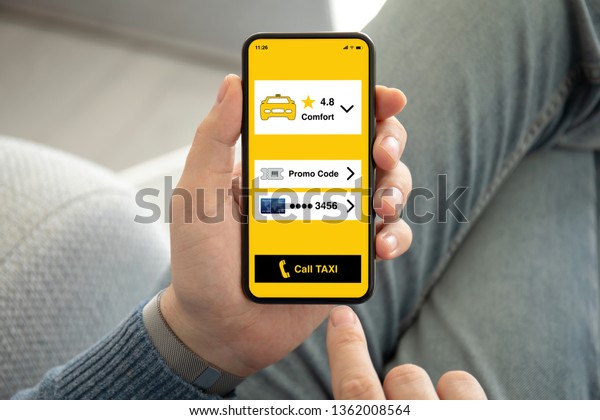 male\
hands holding phone with call taxi app on the\
screen