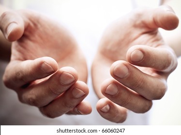 Male hands as if holding something. Focus on finger-tips