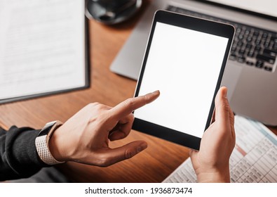 Male Hands Holding Tablet With Blank Background At Workplace. Businessman Working At His Desk With Documents