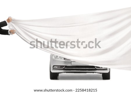 Male hands holding a white piece of cloth in front of a silver car isolated on white background