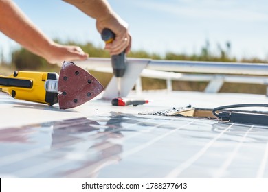 Male Hands Installing Flexible Solar Panel On Rv Campervan Or Repair Camper Car Roof.