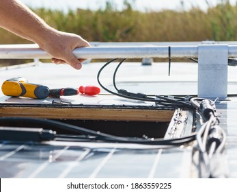 Male Hands Installing Flexible Solar Panel On Rv Campervan Or Repair Camper Car Roof.