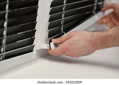 Male hands installing window blinds